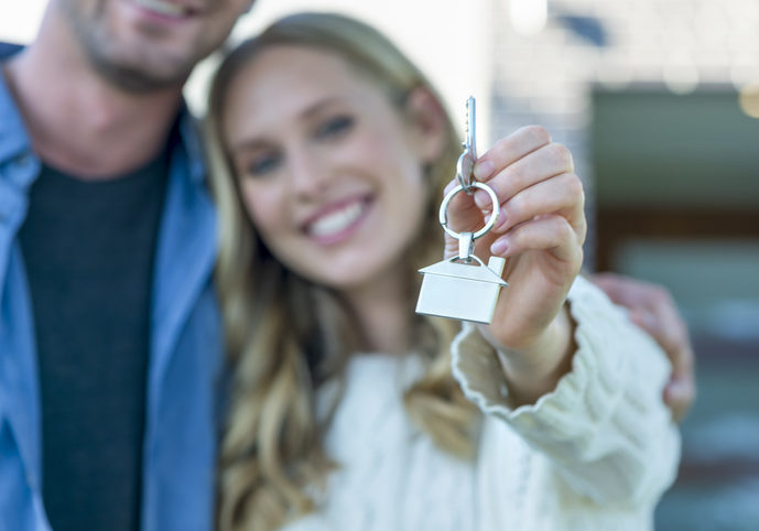 Young couple holding their new house key.